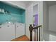 Bright laundry area with a washing machine, dryer, and wire shelving at 6420 Marbut Rd, Lithonia, GA 30058