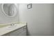 Neat powder room with a simple white vanity and round mirror on the wall at 6420 Marbut Rd, Lithonia, GA 30058
