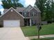 Charming brick two-story home featuring a well-maintained lawn and a two-car garage at 70 Paladin Dr, Covington, GA 30016