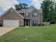 Charming two-story brick home with a well-manicured lawn, a two-car garage and inviting curb appeal at 70 Paladin Dr, Covington, GA 30016