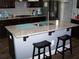 Kitchen island with granite countertop, sink, and seating with dark wood cabinets and stainless steel appliances at 70 Paladin Dr, Covington, GA 30016