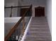 Staircase featuring carpeted steps and a dark wood railing with decorative metal balusters at 70 Paladin Dr, Covington, GA 30016