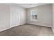 Bright bedroom with plush carpeting, a window, and closet offers a calming and organized space at 1056 Park West Ct, Stone Mountain, GA 30088