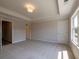Bedroom with tray ceiling, soft carpeting, and bright window with neighborhood views at 1991 Deco Dr, Kennesaw, GA 30144
