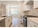 Spacious kitchen with stainless steel appliances, island, white cabinets, and dining area at 1991 Deco Dr, Kennesaw, GA 30144