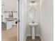 Powder room with a pedestal sink and access to the kitchen at 1991 Deco Dr, Kennesaw, GA 30144