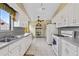 Bright kitchen featuring white cabinetry, appliances, and tile flooring at 217 Colemans Bluff Dr, Woodstock, GA 30188