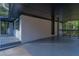 View of the house exterior from the covered carport with freshly painted white brick and a newly refinished floor at 2720 Cavalier Dr, Decatur, GA 30034