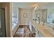 Bright bathroom with double sinks, a soaking tub, wood-look floors, and modern fixtures, creating a spa-like experience at 5637 Valley Loop, Fairburn, GA 30213