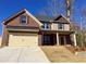 Charming two-story home with a brick and siding facade, covered entry and a two car garage at 5637 Valley Loop, Fairburn, GA 30213