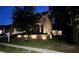 Two-story home featuring exterior landscape lighting, well-maintained lawn, and mature trees at 5637 Valley Loop, Fairburn, GA 30213