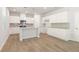 Spacious kitchen featuring white cabinets, granite countertops, stainless appliances, and hardwood floors at 7127 Brushwood Bend (Lot 44), Lithonia, GA 30058
