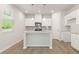 Bright kitchen with white cabinets, island with pendant lighting, and hardwood floors at 7127 Brushwood Bend (Lot 44), Lithonia, GA 30058