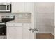 Pantry with metal shelving, white cabinets, granite countertops, and stainless appliances at 7127 Brushwood Bend (Lot 44), Lithonia, GA 30058