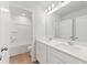Bright bathroom featuring double sinks, a large mirror, modern lighting, and a shower-tub combination, all in a clean, white design at 7133 Brushwood Bend (Lot 43), Lithonia, GA 30058
