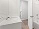 Well-lit bathroom with a vanity, a single sink, a large mirror, and a shower-tub combination, designed with clean, modern fixtures at 7133 Brushwood Bend (Lot 43), Lithonia, GA 30058