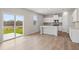 Open-concept kitchen with an island, stainless appliances, and large sliding glass doors to backyard at 7133 Brushwood Bend (Lot 43), Lithonia, GA 30058