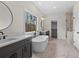 Modern bathroom with a standalone tub, double vanity sinks, and a large window overlooking the greenery at 11350 Bennett Ln, Johns Creek, GA 30097