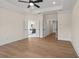 Bright bedroom featuring wood floors, a modern ceiling fan, and view into the bathroom at 11350 Bennett Ln, Johns Creek, GA 30097