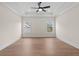 Bright bedroom featuring wood floors, a modern ceiling fan, and natural light from two windows at 11350 Bennett Ln, Johns Creek, GA 30097
