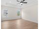 Bright bedroom featuring wood floors, a modern ceiling fan, and natural light from two windows at 11350 Bennett Ln, Johns Creek, GA 30097