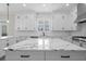 Large kitchen island with white marble and white cabinets at 11350 Bennett Ln, Johns Creek, GA 30097