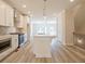 Bright kitchen boasts stainless steel appliances, quartz counters, large island, and modern pendant lighting at 1979 Deco Dr, Kennesaw, GA 30144
