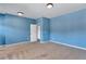 Spacious blue bedroom with plush carpeting and ample natural light, perfect for relaxation at 385 Hinton Chase Pkwy, Covington, GA 30016