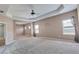 Inviting bedroom featuring tray ceilings, a ceiling fan, and views into other rooms creating an open and airy feel at 385 Hinton Chase Pkwy, Covington, GA 30016