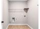 Simple laundry room with tile flooring, a wire shelf, and washer and dryer hookups at 385 Hinton Chase Pkwy, Covington, GA 30016