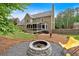 Inviting backyard with a stone fire pit, yellow chairs, and a screened-in porch at 4067 Silver Fir Ct, Marietta, GA 30066