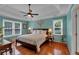 This bedroom features a tray ceiling, fan, hardwood floors and natural light from windows at 4067 Silver Fir Ct, Marietta, GA 30066
