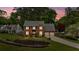 Beautiful two-story brick home at dusk, featuring an attached garage and landscaped front yard with lovely lighting at 4067 Silver Fir Ct, Marietta, GA 30066