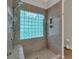 A modern tiled shower with glass block window, built-in seat, and sleek fixtures at 4067 Silver Fir Ct, Marietta, GA 30066