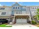 Rear exterior view of townhome featuring a balcony above a garage and private parking at 510 Suwanee Pass Ln, Suwanee, GA 30024