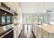 Modern kitchen with center island, stainless steel appliances, and a view to the living area at 510 Suwanee Pass Ln, Suwanee, GA 30024