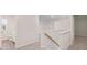 Upstairs hallway with carpet, access to a bathroom, and a view of the staircase at 7139 Brushwood Bend - Lot 42, Lithonia, GA 30058