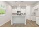 Modern kitchen with white cabinets, stainless steel appliances, granite countertops, and a center island at 7139 Brushwood Bend - Lot 42, Lithonia, GA 30058