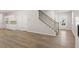 Open concept living area featuring hardwood floors, a staircase, and ample natural light at 7139 Brushwood Bend - Lot 42, Lithonia, GA 30058