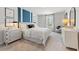 Bright bedroom features a cozy bed, modern blue wall accents, and ample natural light at 7145 Brushwood Bend - Lot 41, Lithonia, GA 30058