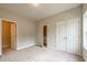 Bright bedroom with plush carpeting, neutral walls, and a view of the staircase through the doorway at 1903 Deco Dr, Kennesaw, GA 30144