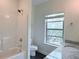 Bright bathroom with granite countertop vanity, shower-tub, and window offering natural light at 3076 Quantum Ln, Atlanta, GA 30341