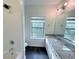 Well lit bathroom features a granite countertop vanity, shower-tub, and window offering natural light at 3076 Quantum Ln, Atlanta, GA 30341