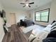 Light-filled bedroom with ceiling fan, window, and dark-colored furniture and grey-tone wood flooring at 3076 Quantum Ln, Atlanta, GA 30341