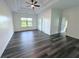Expansive primary bedroom featuring tray ceiling, ceiling fan and grey-tone wood flooring at 3076 Quantum Ln, Atlanta, GA 30341