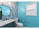 Charming bathroom with blue walls, a circular mirror, vanity, and elegant lighting at 4545 Evandale Way, Cumming, GA 30040
