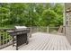 Spacious outdoor deck with a stainless steel grill, perfect for entertaining with a beautiful wooded backdrop at 4545 Evandale Way, Cumming, GA 30040