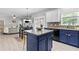 Open-concept kitchen with an island that flows to a living room with fireplace at 4545 Evandale Way, Cumming, GA 30040