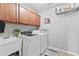 Functional laundry room with white washer and dryer, overhead cabinets, and a convenient utility sink at 4545 Evandale Way, Cumming, GA 30040