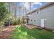 Backyard featuring a small deck, grassy area, and mature trees, creating a private outdoor retreat at 875 Waterbrook Ct, Roswell, GA 30076